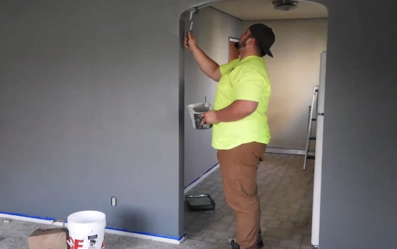 Professional painter painting an interior wall for home repairs in Green Bay, Wisconsin